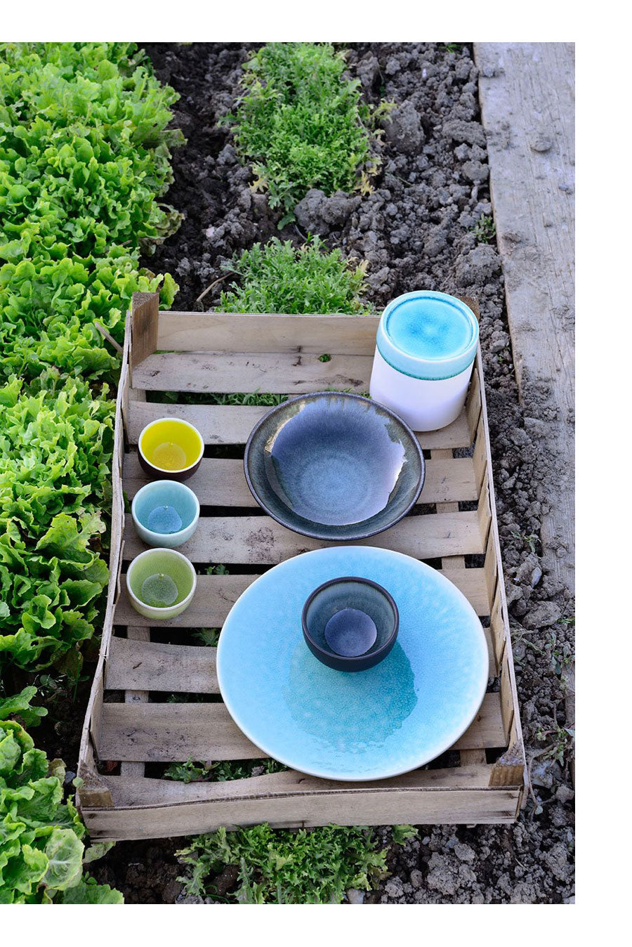 A group of plates and cups on a wooden crate